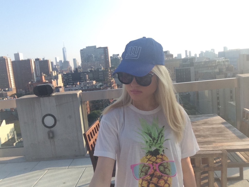 girl in baseball cap with view of NYC and freedom tower Caitlin Hartley of Styled American http://styledamerican.com/nycs-newest-resident/
