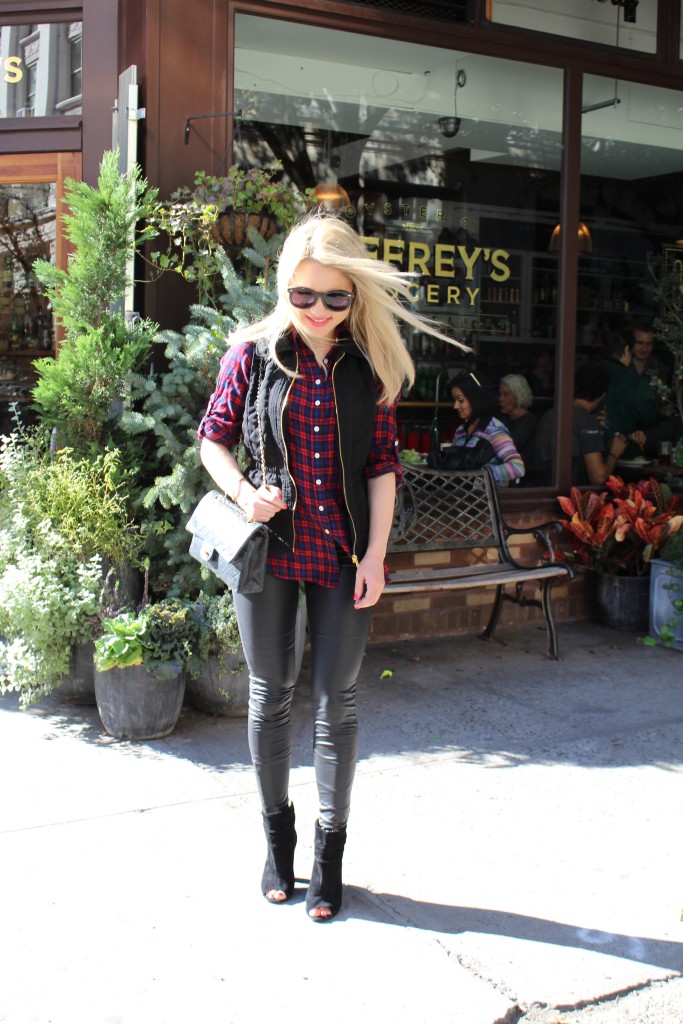 Caitlin Hartley of Styled American girl in liquid leggings, flannel top and black vest