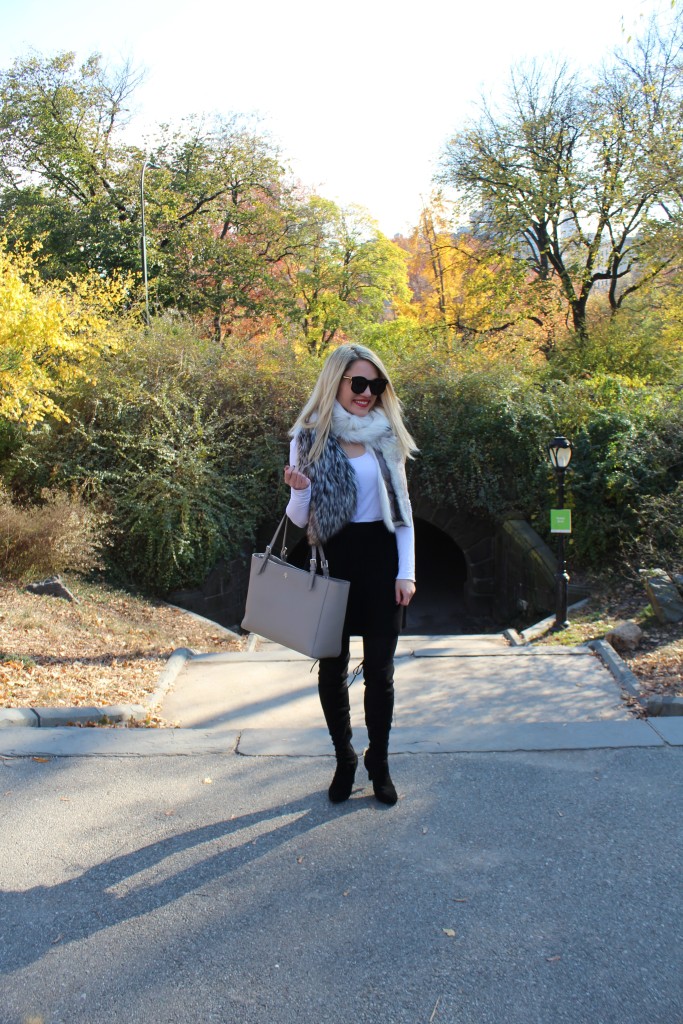 Caitlin Hartley of Styled American girl in faux fur scarf, black skirt, black tights and black over the knee boots