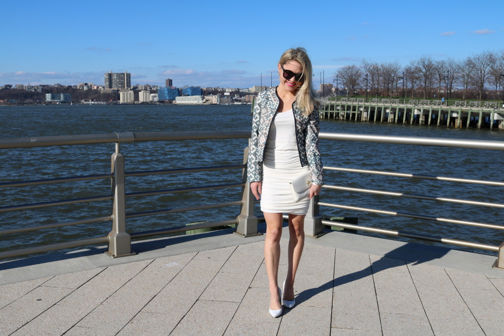 Caitlin Hartley of Styled American girl in front of the Hudson River in white dress and blue aztec blazer