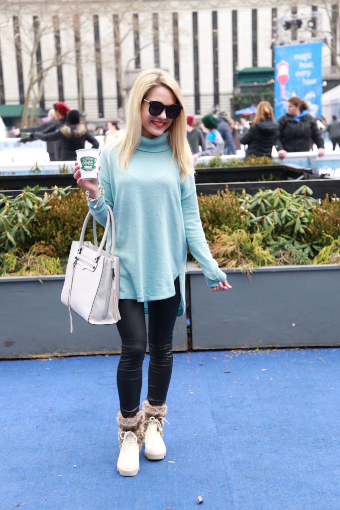 Caitlin Hartley of Styled American powder blue turtleneck sweater over black leggings and snow boots