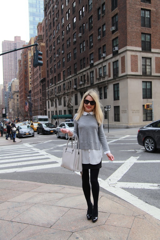 Caitlin Hartley of Styled American grey sweater with white collar, grey rebecca minkoff tote, black short skirt