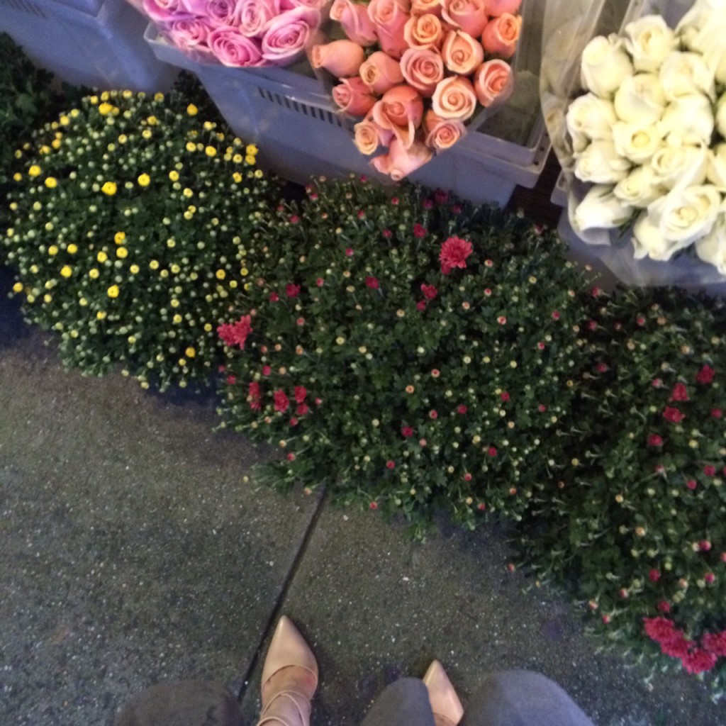 Caitlin Hartley of Styled American blogger in nude pumps next to flower stand
