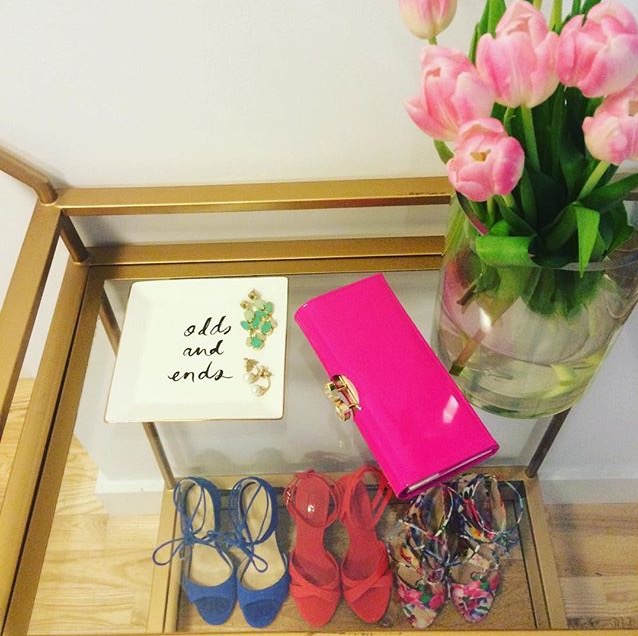 Caitlin Hartley of Styled American styled gold bar cart with pumps, a trinket tray, pink clutch and flowers