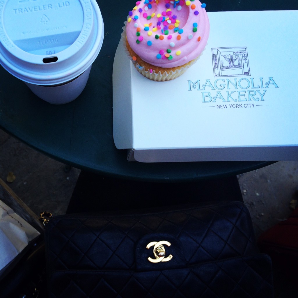 Caitlin Hartley of Styled American Magnolia Bakery box with coffee, pink cupcake and black chanel bag