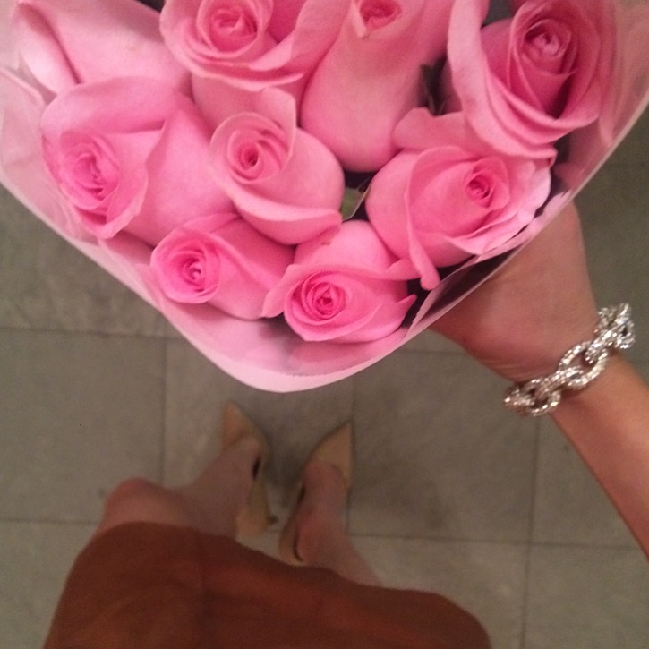 Caitlin Hartley of Styled American girl holding pink roses wearing bauble bracelet