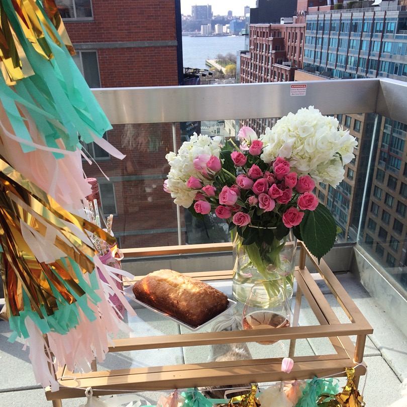 Caitlin Hartley of Styled American styled gold bar cart with roses, lemon bread and huge balloon with tassels