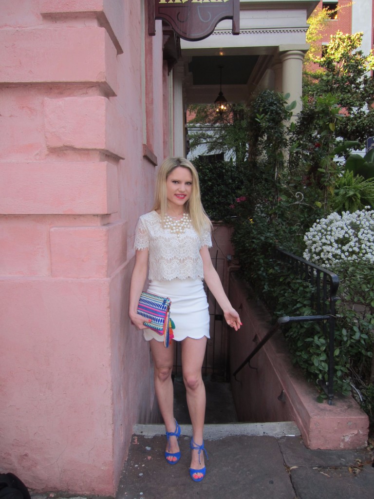 Caitlin Hartley of Styled American lace crop top, scalloped skirt, colorful wristlet and blue pumps