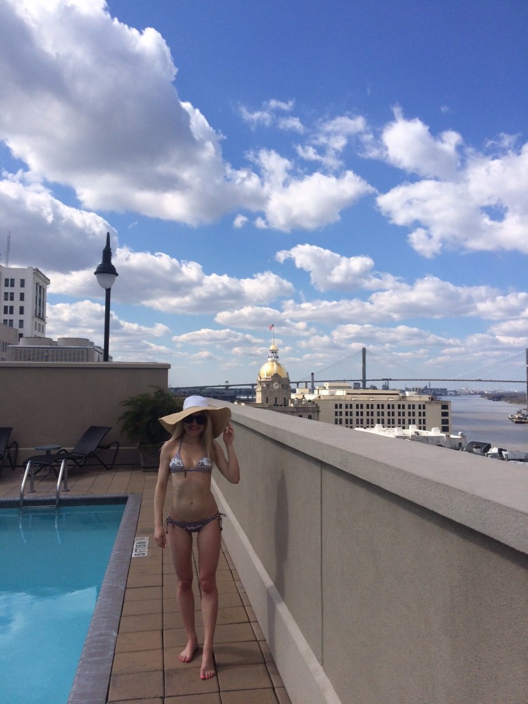 Caitlin Hartley of Styled American in tigerlily bikini, color block floppy hat overlooking Savannah
