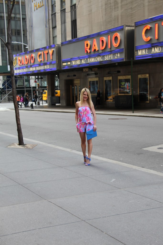 Caitlin Hartley of Styled American pink floral romper, blue bag and blue pumps