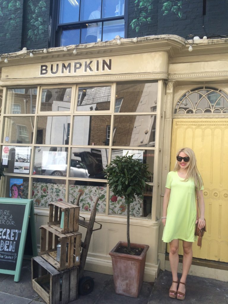 Caitlin-of-Styled-American-in-front-of-bumpkin-chelsea-in-yellow-dress-and-wedges