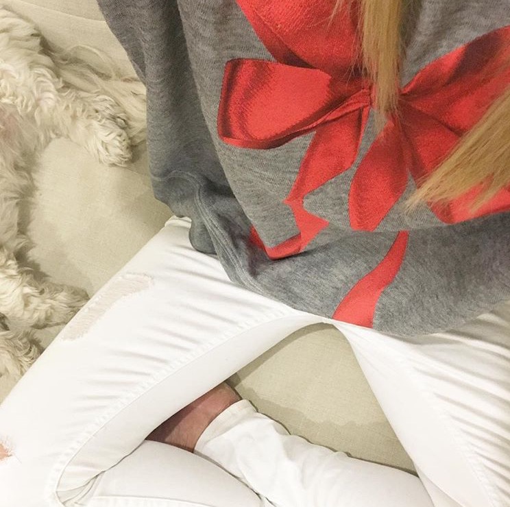 bow-sweatshirt-white-denim-sitting-on-couch-with-with-puppy http://styledamerican.com/latest-roundup/